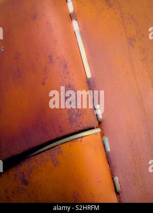 Vivid orange colored rust on old refrigerator Stock Photo