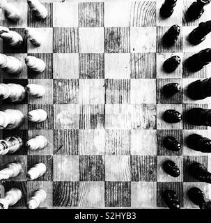 Old, rustic wooden chess board game from above view in black and white Stock Photo