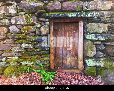 Wooden door in an old stone wall Stock Photo