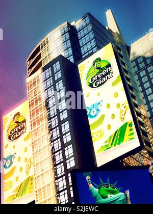 Huge electronic billboard featuring green giant vegetables above the M&M candy store in Times Square, New York City, USA Stock Photo