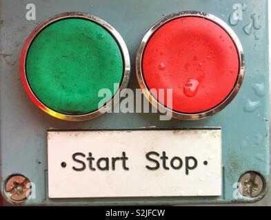 A red and a green button with a sign saying stop or start in a decision-making image about choice Stock Photo