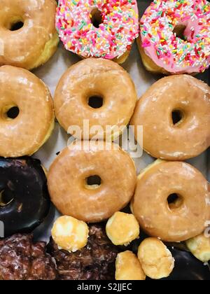 Colorful donuts in box on beige background Stock Photo - Alamy