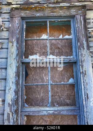 A window with the glass broken out of it that is in an abandoned ...