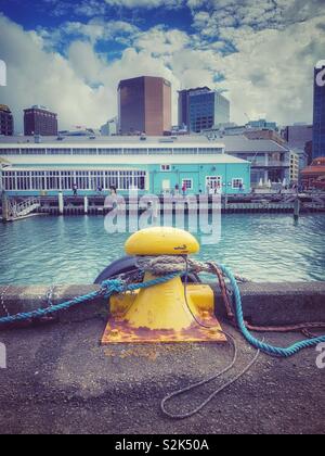 Yellow bollard on a dock in the city Stock Photo