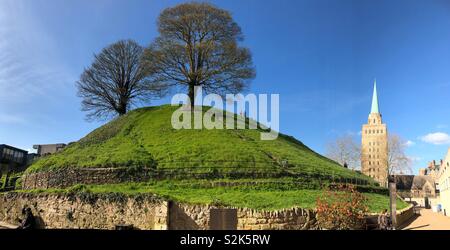 Oxford Castle Mound (or Norman motte) with trees and people on the mound with Nuffield College Library Tower.