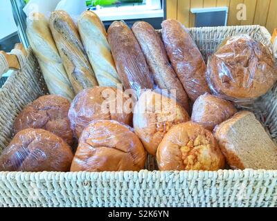 Wicker basket full of different types of bread Stock Photo