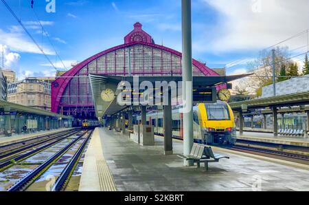 Antwerp central railway station under a blue sky after the rain with a train on the tracks next to the platform, waiting to leave Stock Photo