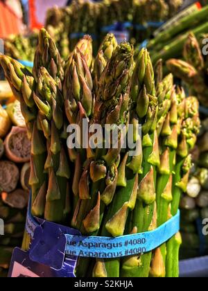 Full frame of finest fresh delicious ripe green blue asparagus on display and for sale at the local produce market. Stock Photo