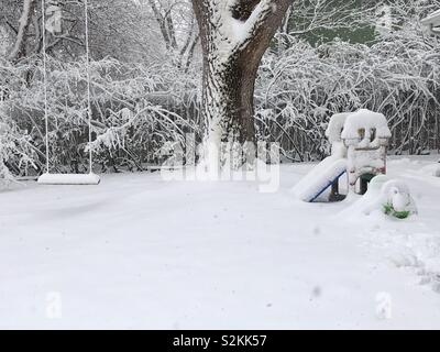 April 10, 2019. - Fort Collins Colorado.  Yard with shrubs,  trees and children’s outdoor activities covered in snow during the second “polar cyclone” this year. Stock Photo