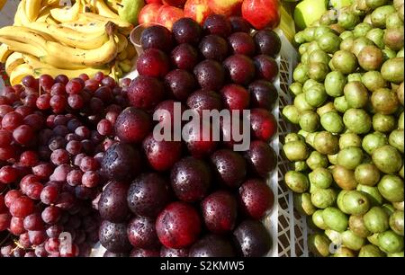 Fresh and delicious plums, grapes, bananas, apples and pears in the market square. Stock Photo