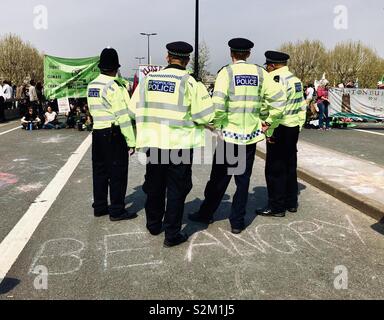 Police gathered in front of the extinction rebellion protest on Waterloo bridge, ‘be angry’ is written in front of them on the road April 2019