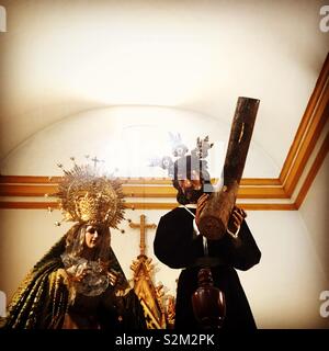 Images of the Virgin Mary and Jesus Christ carrying the cross are displayed in a church in Prado del Rey, Sierra de Cadiz, Andalucia, Spain Stock Photo