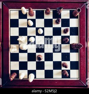 Flat lay view of a mini chess board captured in mid-game Stock Photo