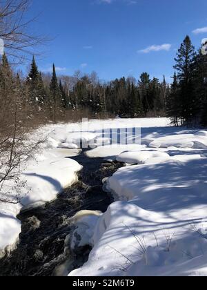 Snow covered river in Mercer, Wisconsin Stock Photo