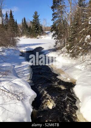 Snow covered river in Mercer, Wisconsin Stock Photo