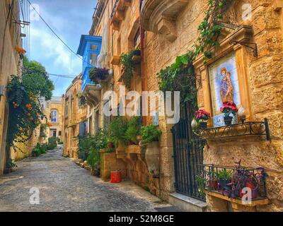 Vibrant colours and floral displays adorn a quiet street in Rabat, Malta Stock Photo
