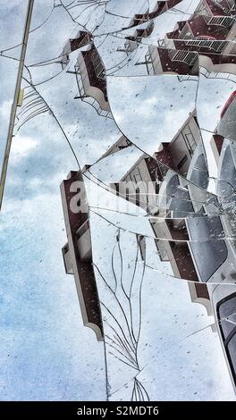 Buildings and sky reflected in a shattered mirror on a street Stock Photo