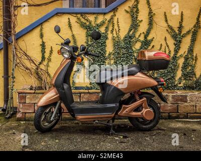 vespa scooter parked in front of house Stock Photo