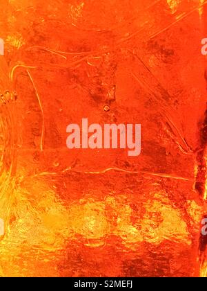 Decorative brightly colored orange and yellow stained textured translucent glass with a random abstract pattern. Stock Photo