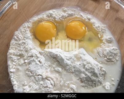 Two eggs in a bowl of white self raising flour Stock Photo
