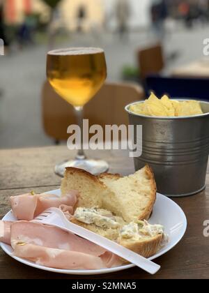 Italian snack pause at the bar with potatoes, bread, mortadella and a glass of beer Stock Photo