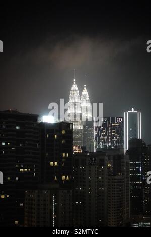 Kuala Lumpur by night. Apartment buildings and one some illuminated skyscraper. Stock Photo