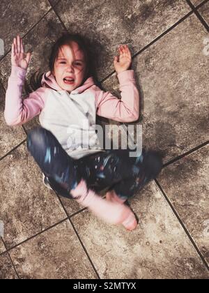 Young girl having a temper tantrum on the floor Stock Photo