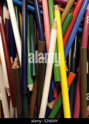 A bin full of bright colored pencils randomly placed Stock Photo