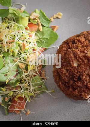 A healthy lunch of a gourmet scotch egg and salad Stock Photo
