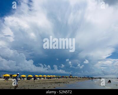 Apfelt Park Beach, east end of Galveston, with colorful rental chairs and umbrellas, against a beautiful blue sky. 2018 Galveston TX Stock Photo