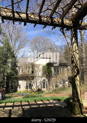 Manor House at Gibbs Gardens framed by rose trellis in early spring Stock Photo