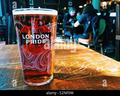 A pint of Fuller’s London Pride beer on a table in a pub. Stock Photo