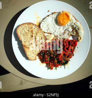 Red sauce, fried eggs and toasted bread in a plate in restaurant in Fatima, Portugal Stock Photo