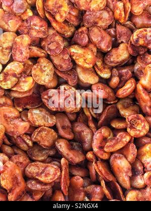 Full frame of dried fava beans dusted in red chili powder as a delicious natural and popular snack. Stock Photo