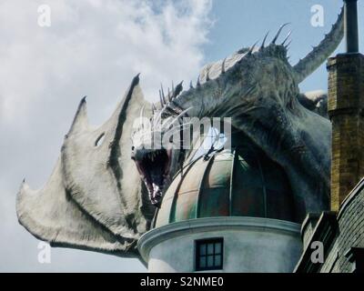 The Ukrainian Ironbelly Dragon looming down from atop the Gringotts Bank in Diagon Alley at the Wizarding World of Harry Potter, Universal Studios, Florida. Stock Photo