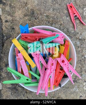 Colourful plastic clothes pegs on paving slab Stock Photo