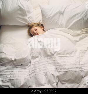 Small boy sleeping in parents bed Stock Photo