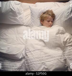 Small boy sleeping in parents bed Stock Photo
