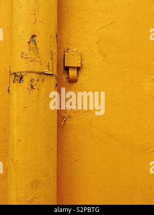 Yellow pipe on yellow wall in Chinatown Singapore Stock Photo