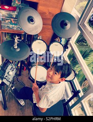 Young boy playing electronic drums or electronic battery Stock Photo