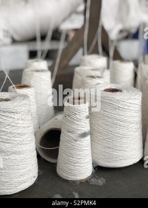 Spools of greige natural cotton yarn Stock Photo