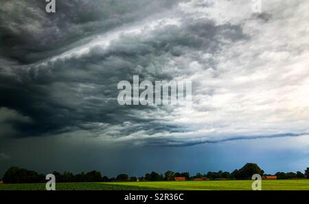 Dark threatening storm clouds rolling in over a Countryside landscape Stock Photo
