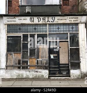 The shop front of a furniture, antiques and valuers business in Wallasey, Wirral, England. Stock Photo