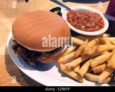 Pulled pork sandwich, french fries and baked beans served in a casual southern barbecue restaurant, Tampa, Florida, USA Stock Photo