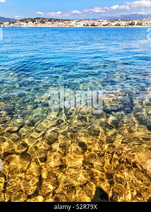 Rocks under water in morning light with gentle ripples on the surface of the sea Stock Photo