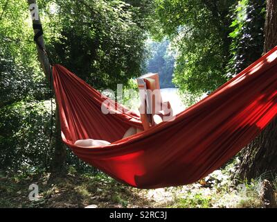 Relaxing in the heat in a hammock Next to the River Tarn, Sainte-Enimie, France Stock Photo