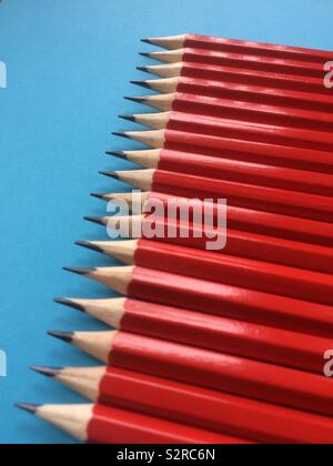 Raw of red graphite pencils on blue background Stock Photo