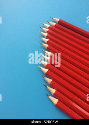 Set of red graphite pencils isolated on a blue background Stock Photo