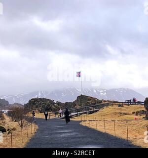 Tourists walking in rift valley between North American and Eurasian tectonic plates in Þingvellir ,Iceland Stock Photo
