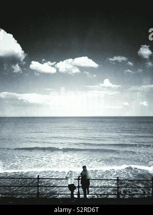Young couple looking out at the ocean Stock Photo